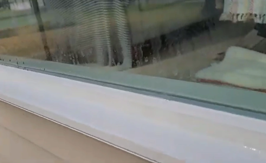 Rainwater drying into mineral spots on a San Clemente window